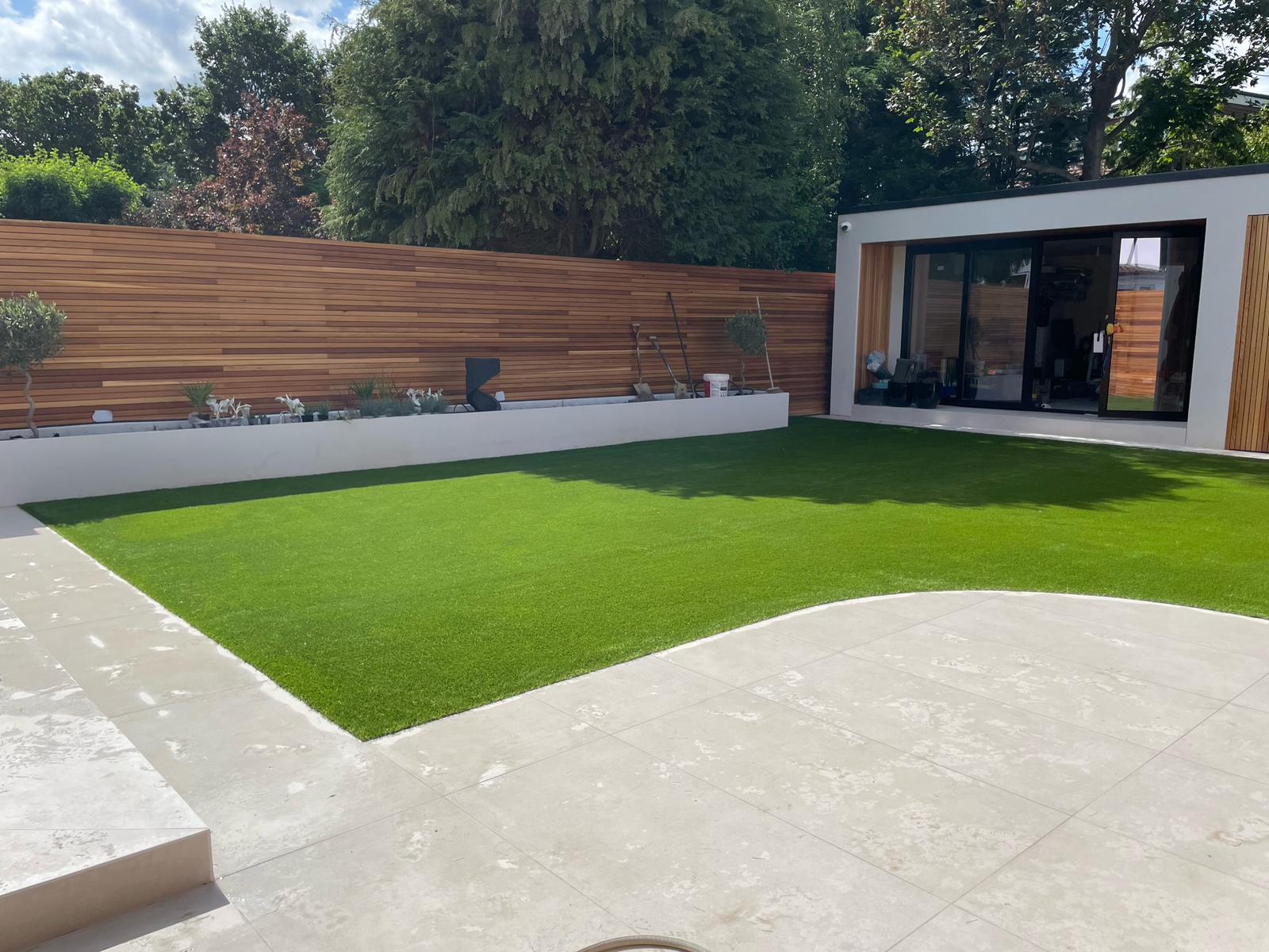Modern garden with artificial turf and patio