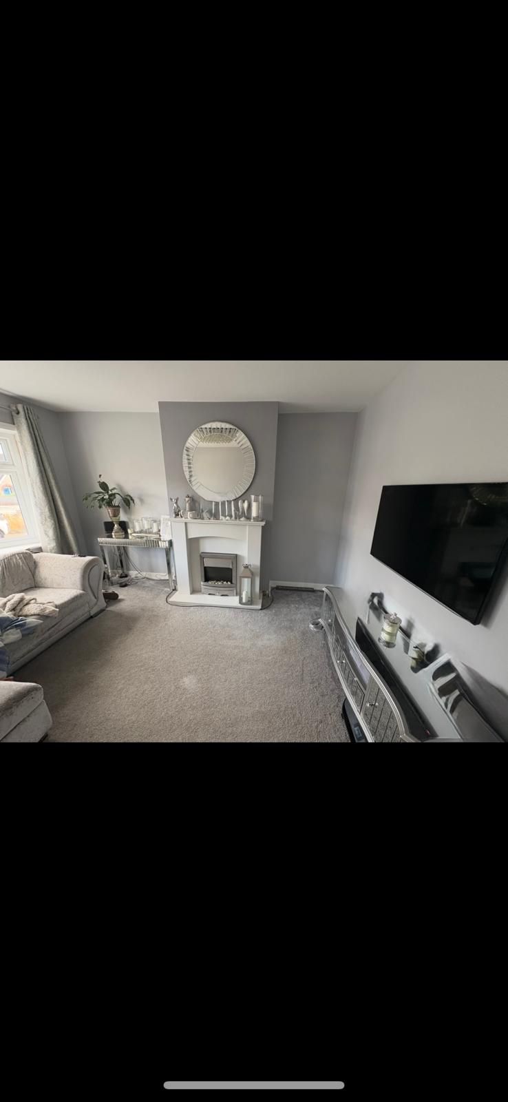 Before: plain living room with carpet and standard fireplace