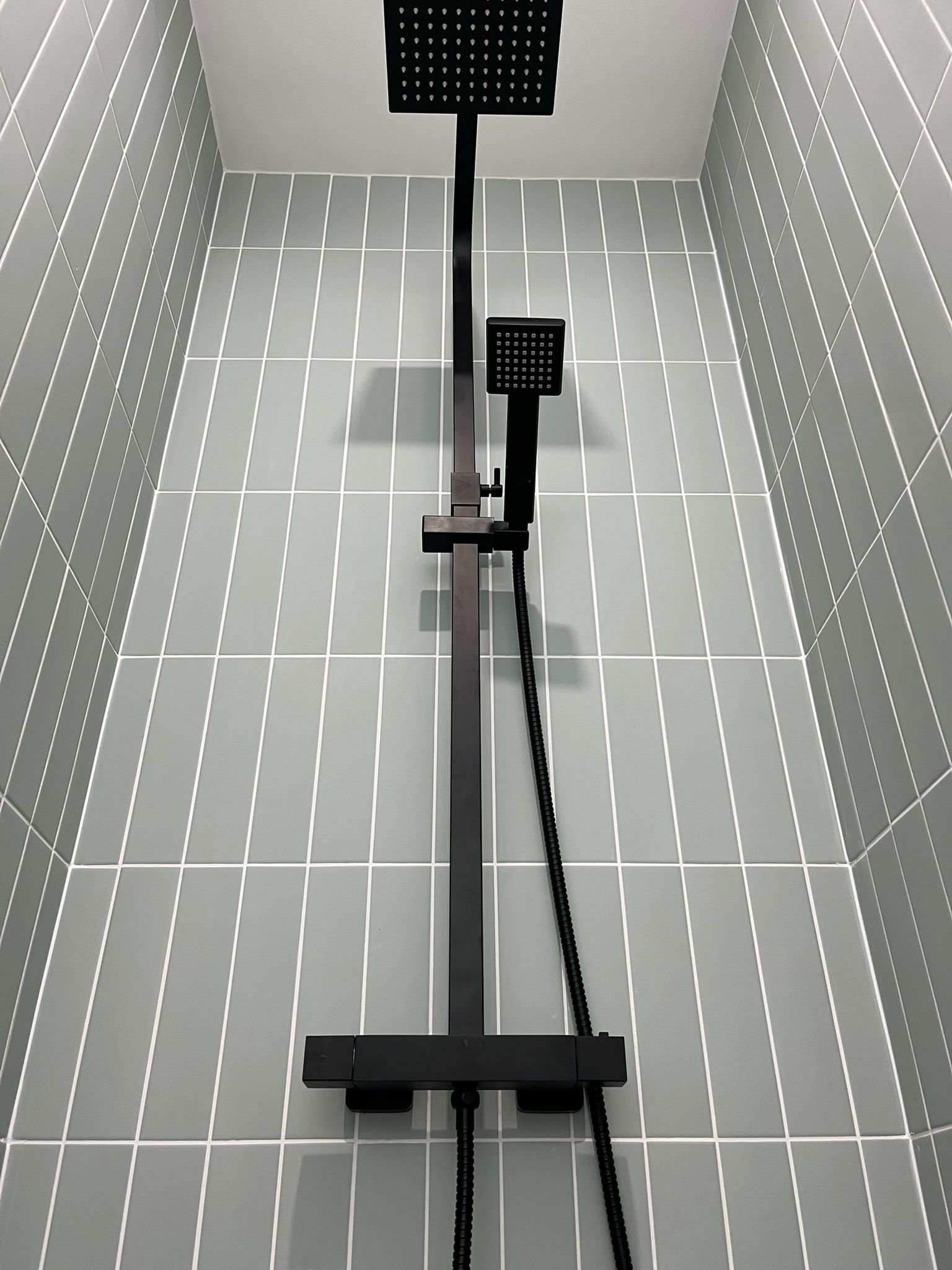 Black rain showerhead with subway tile surround