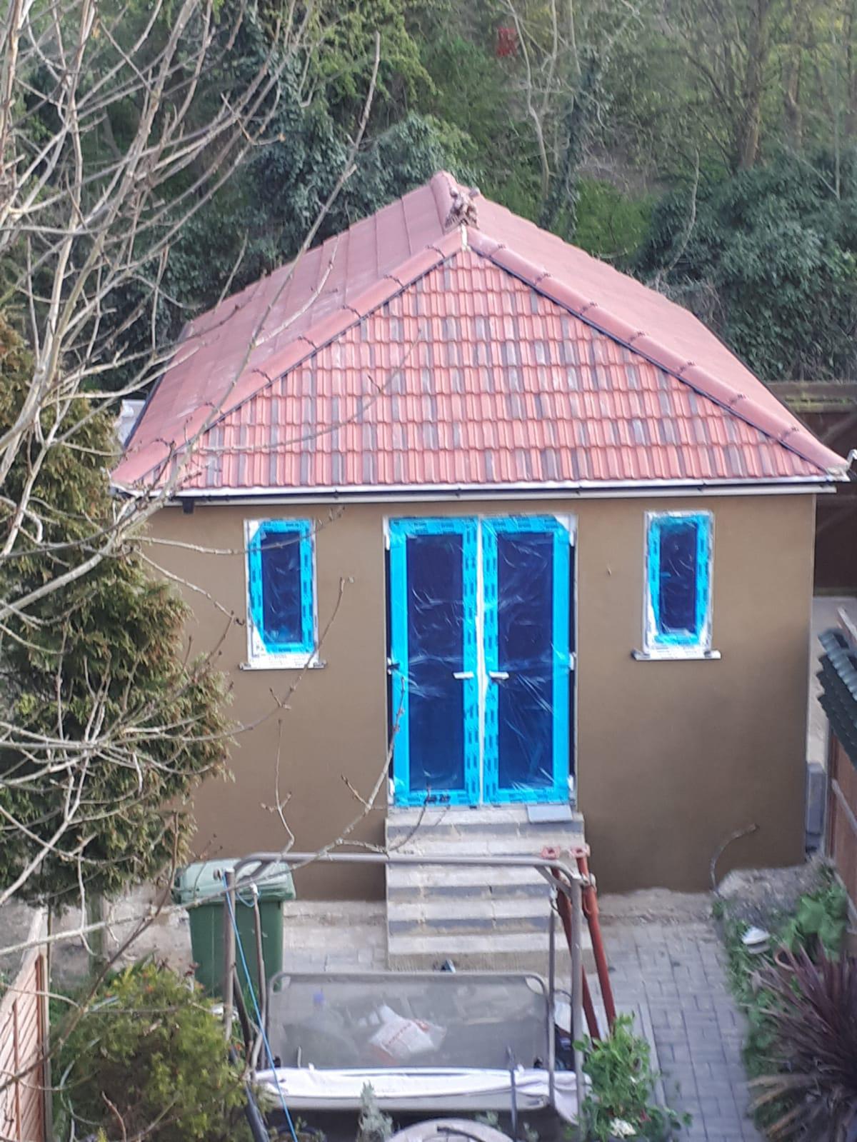 After: fully transformed outbuilding with rendered walls and tiled roof